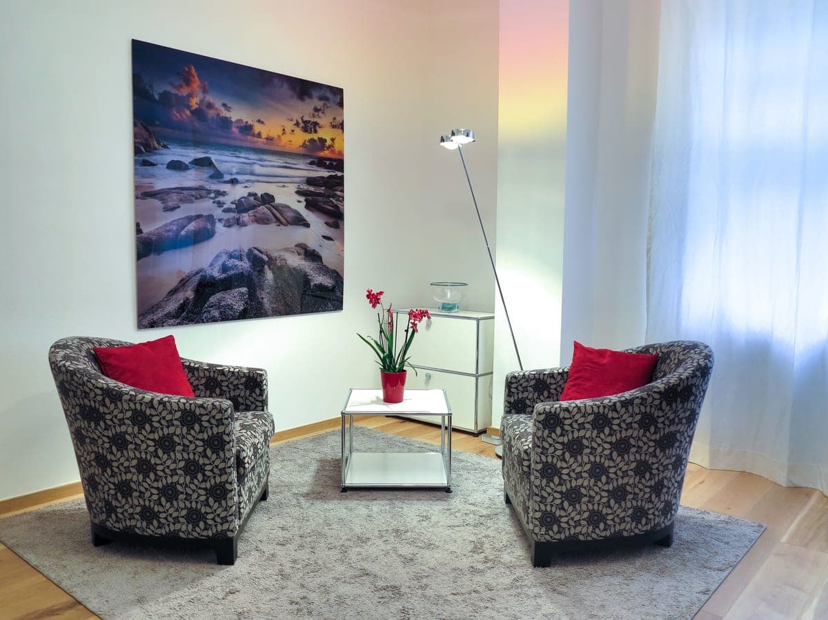 A tall floor lamp lighting a whole living room by bouncing light off the ceiling
