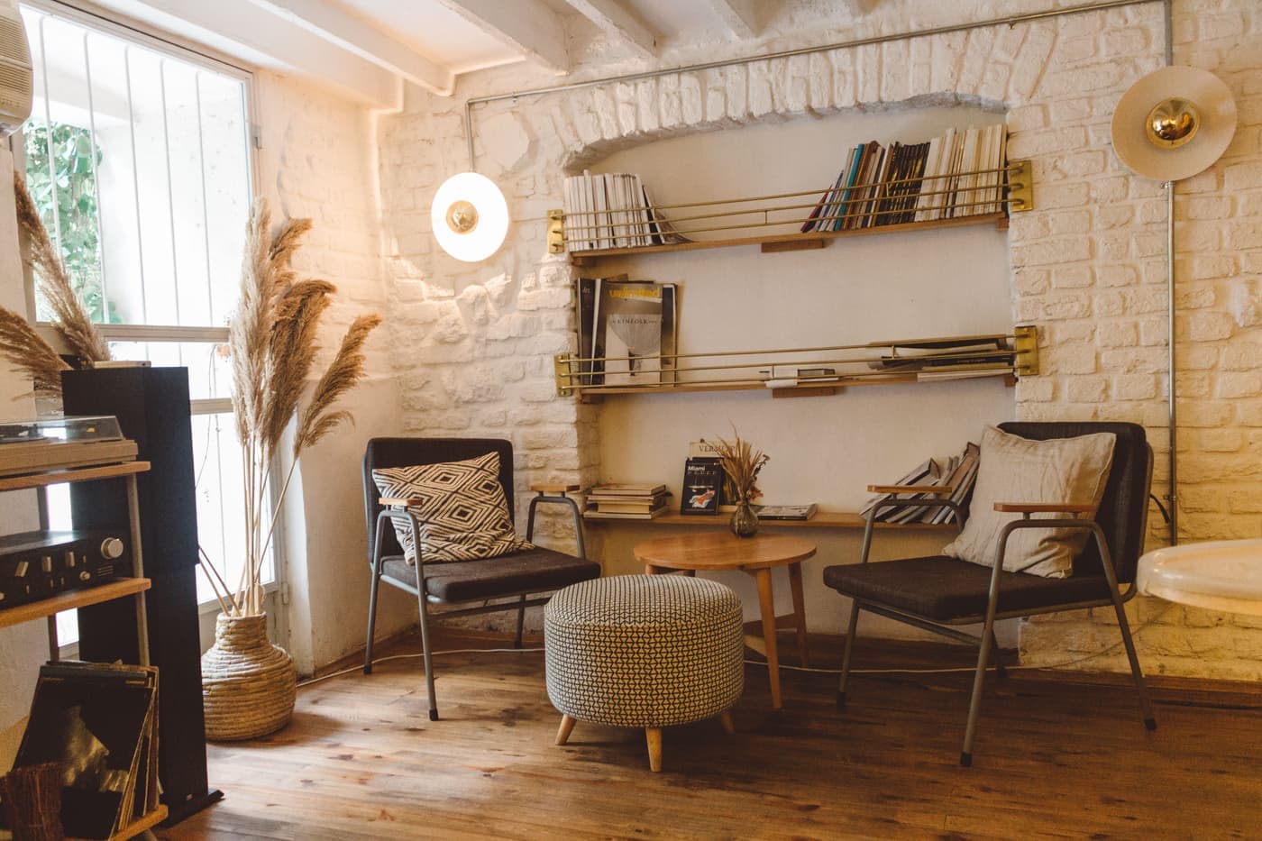 A tall floor lamp standing beside an armchair in a softly lit room after dark
