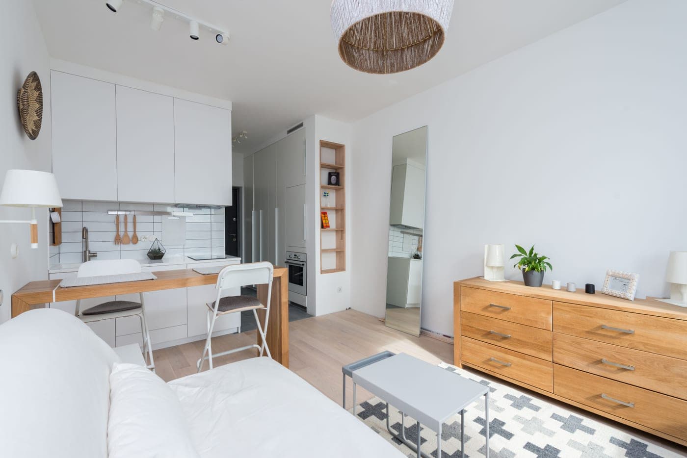 A rented apartment room with a plug-in lamp and no fixture on the bare ceiling